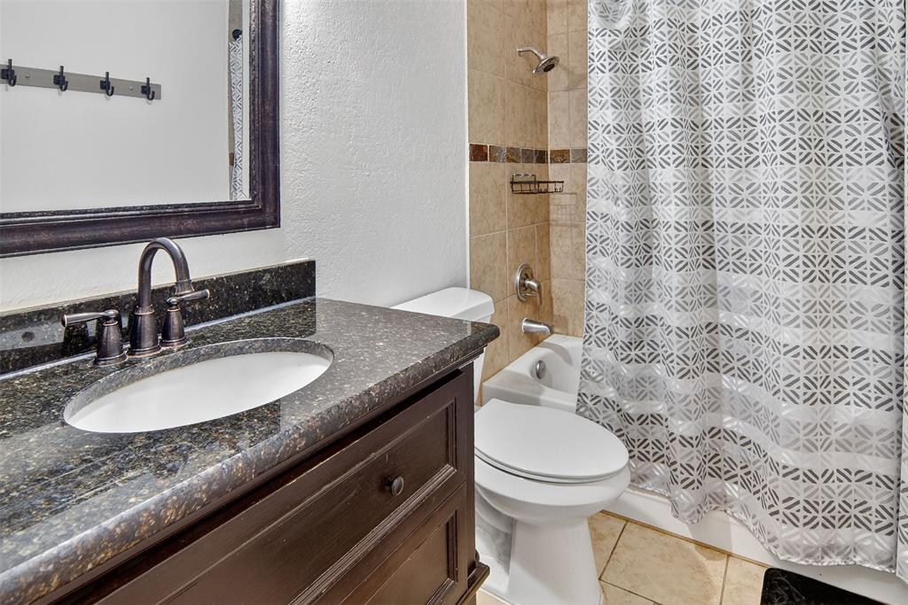 6004 Old Mill Court Watauga, TX 76148 - Photo 16 of 26 a bathroom with a granite countertop sink toilet and shower