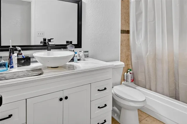 a bathroom with a sink a toilet a mirror and shower curtain
