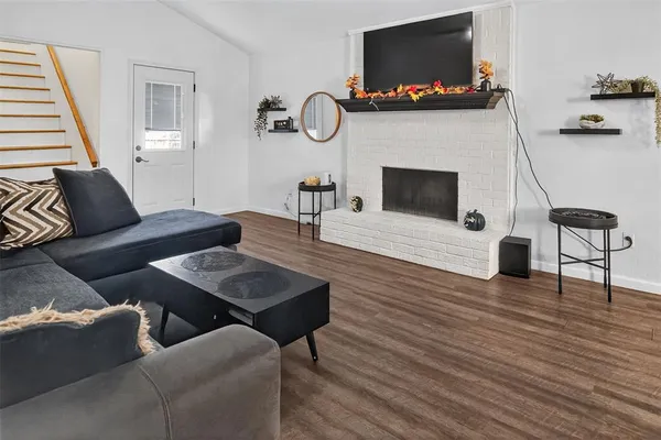 a living room with furniture a flat screen tv and a fireplace