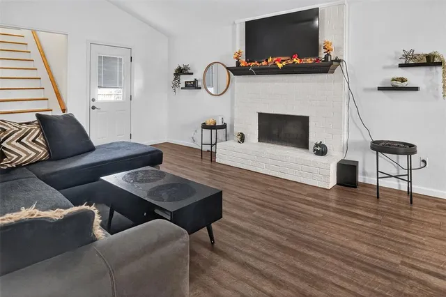 a living room with furniture a flat screen tv and a fireplace