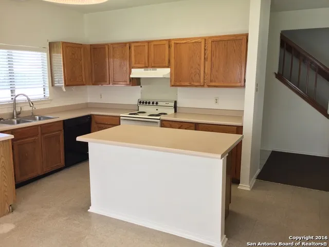 a kitchen with a sink a stove and cabinets