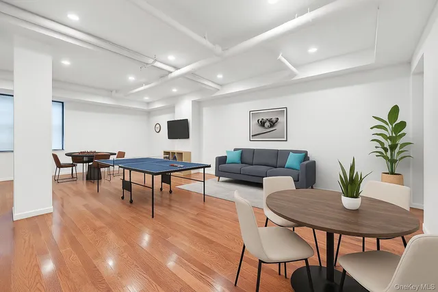 a living room with furniture potted plant wooden floor and a table