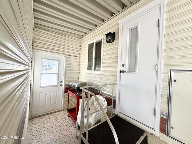 a view of a house with a barbeque and wooden stairs