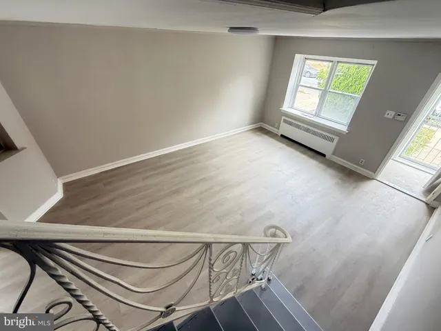 a view of room with window and wooden floor