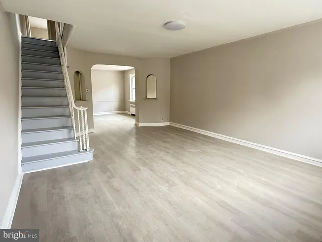 a view of a livingroom with wooden floor and staircase