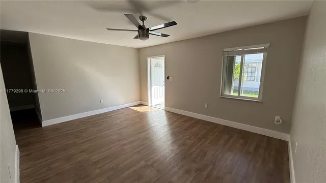 an empty room with wooden floor and entrance