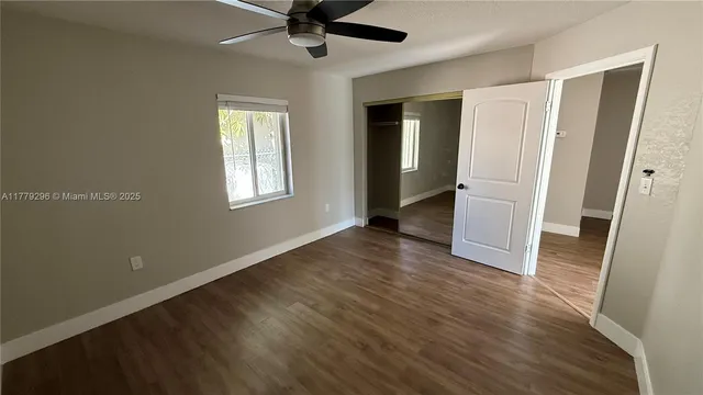 a view of a livingroom with wooden floor and a ceiling fan
