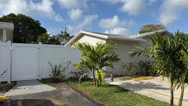 a view of a house with a yard and potted plants