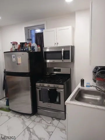 a kitchen with granite countertop a stove and a microwave