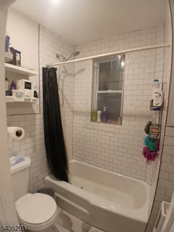 a view of a brick house with many windows next to a yard