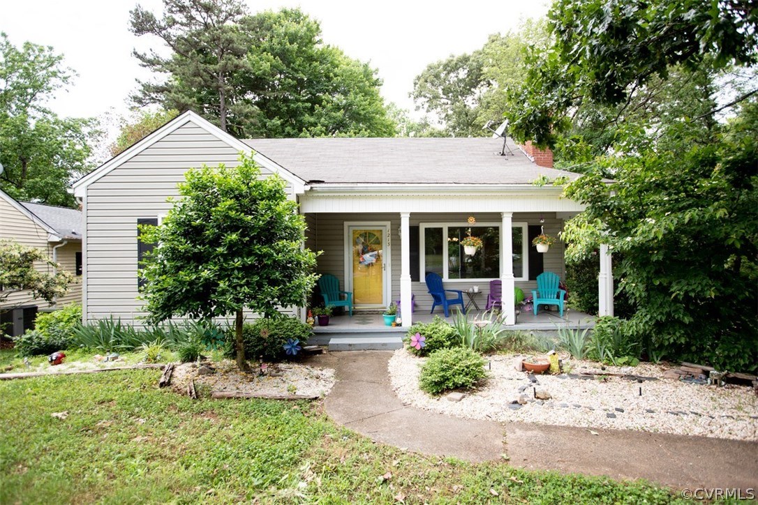 a front view of a house with a yard and potted plants