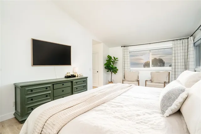 a bedroom with a large bed and a flat screen tv