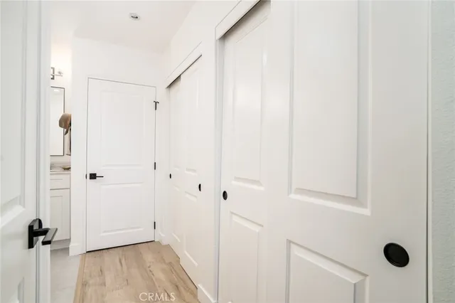 a view of a hallway with wooden floor and closet area