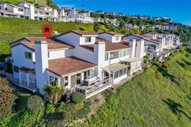 an aerial view of multiple houses with a yard