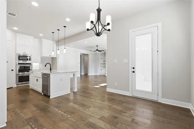 wooden floor in an empty room with a ceiling fan