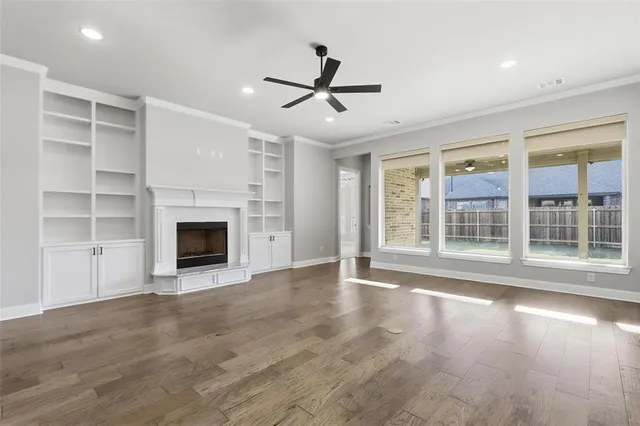 a view of empty room with wooden floor and fireplace