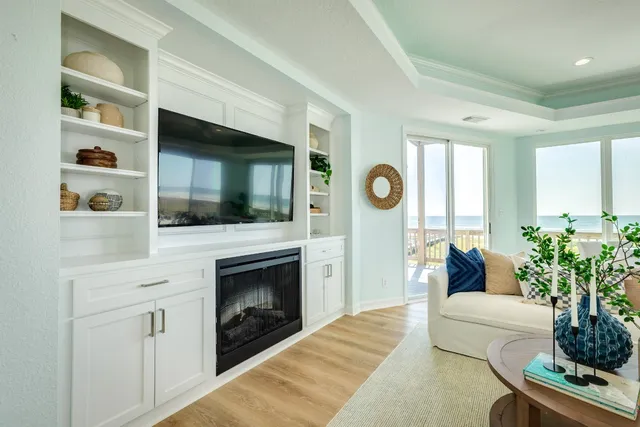 a living room with furniture a flat screen tv and a fireplace