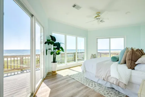 a bedroom with a bed and large windows