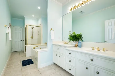 a spacious bathroom with a double vanity sink a large mirror a shower and a bathtub