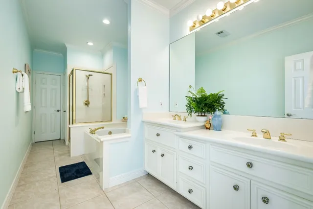 a spacious bathroom with a double vanity sink a large mirror a shower and a bathtub