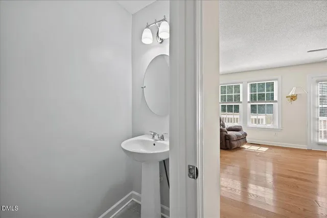 a view of a bathroom with a sink mirror and window