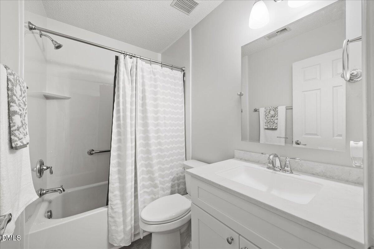 1932 Stroll Circle Fuquay-Varina, NC 27526 - Photo 13 of 24 a bathroom with a granite countertop sink a toilet and shower