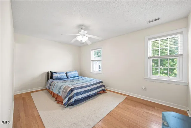 a bedroom with a bed lamp and a window