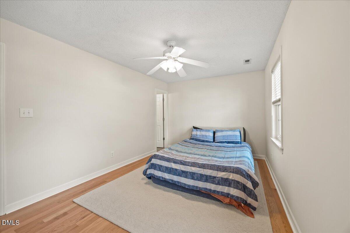 1932 Stroll Circle Fuquay-Varina, NC 27526 - Photo 15 of 24 a bedroom with a bed and a chandelier fan