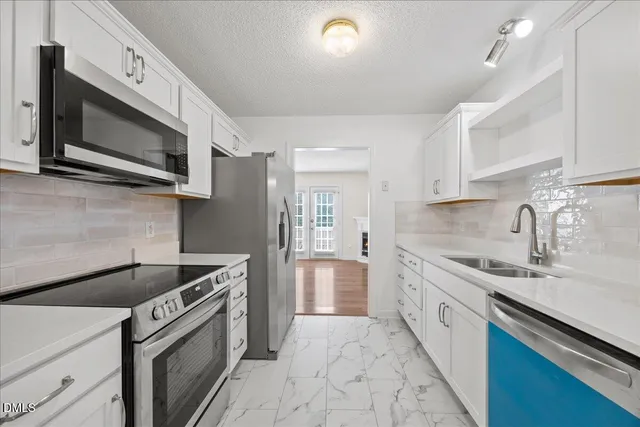 a kitchen with stainless steel appliances granite countertop a sink stove and microwave