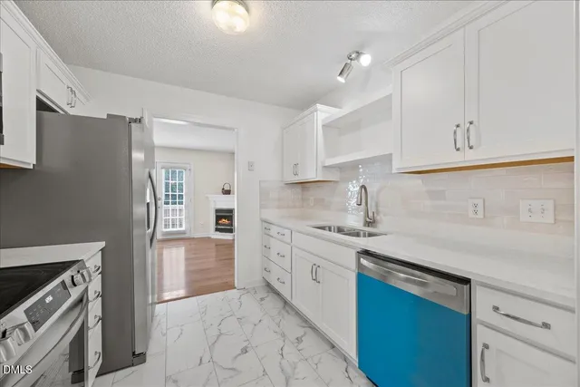 a kitchen with granite countertop a sink stainless steel appliances and cabinets