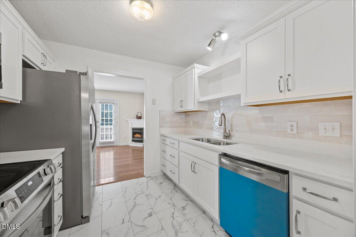 1932 Stroll Circle Fuquay-Varina, NC 27526 - Photo 7 of 24 a kitchen with granite countertop a sink stainless steel appliances and cabinets