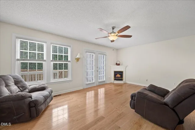 a living room with furniture a fireplace and a chandelier