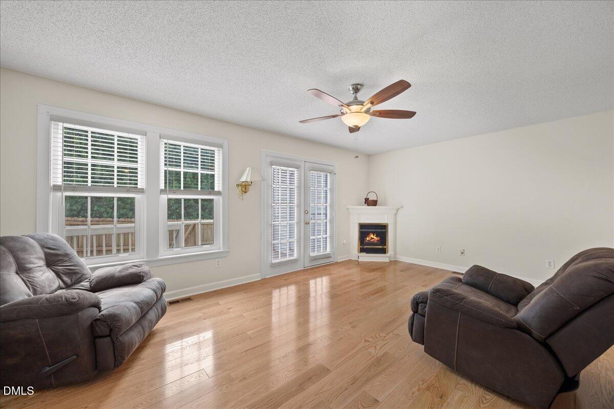 1932 Stroll Circle Fuquay-Varina, NC 27526 - Photo 10 of 24 a living room with furniture a fireplace and a chandelier