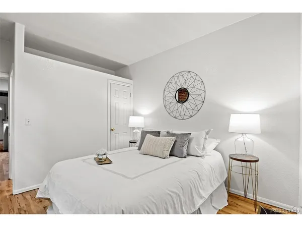 a bedroom with a bed and a lamp on dresser