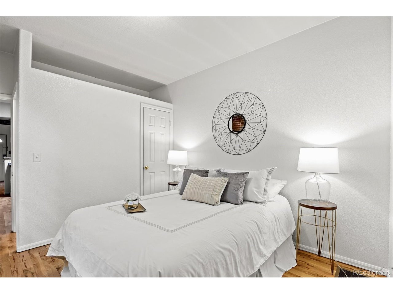321 Inca Street Denver, CO 80223 - Photo 12 of 27 a bedroom with a bed and a lamp on dresser