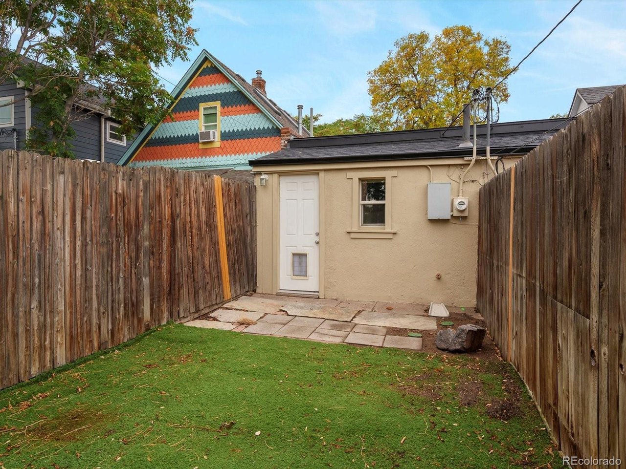 321 Inca Street Denver, CO 80223 - Photo 19 of 27 a backyard of a house with chairs and wooden fence