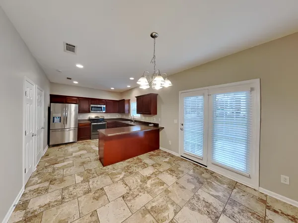 a large kitchen with kitchen island a stove a sink dishwasher a refrigerator and a fireplace