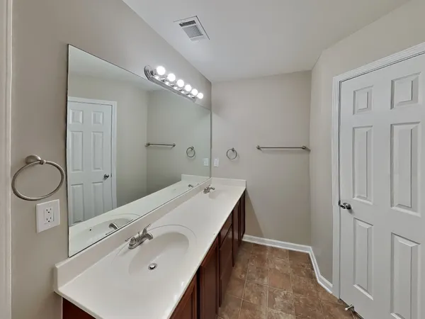 a spacious bathroom with a double vanity sink a mirror and a shower