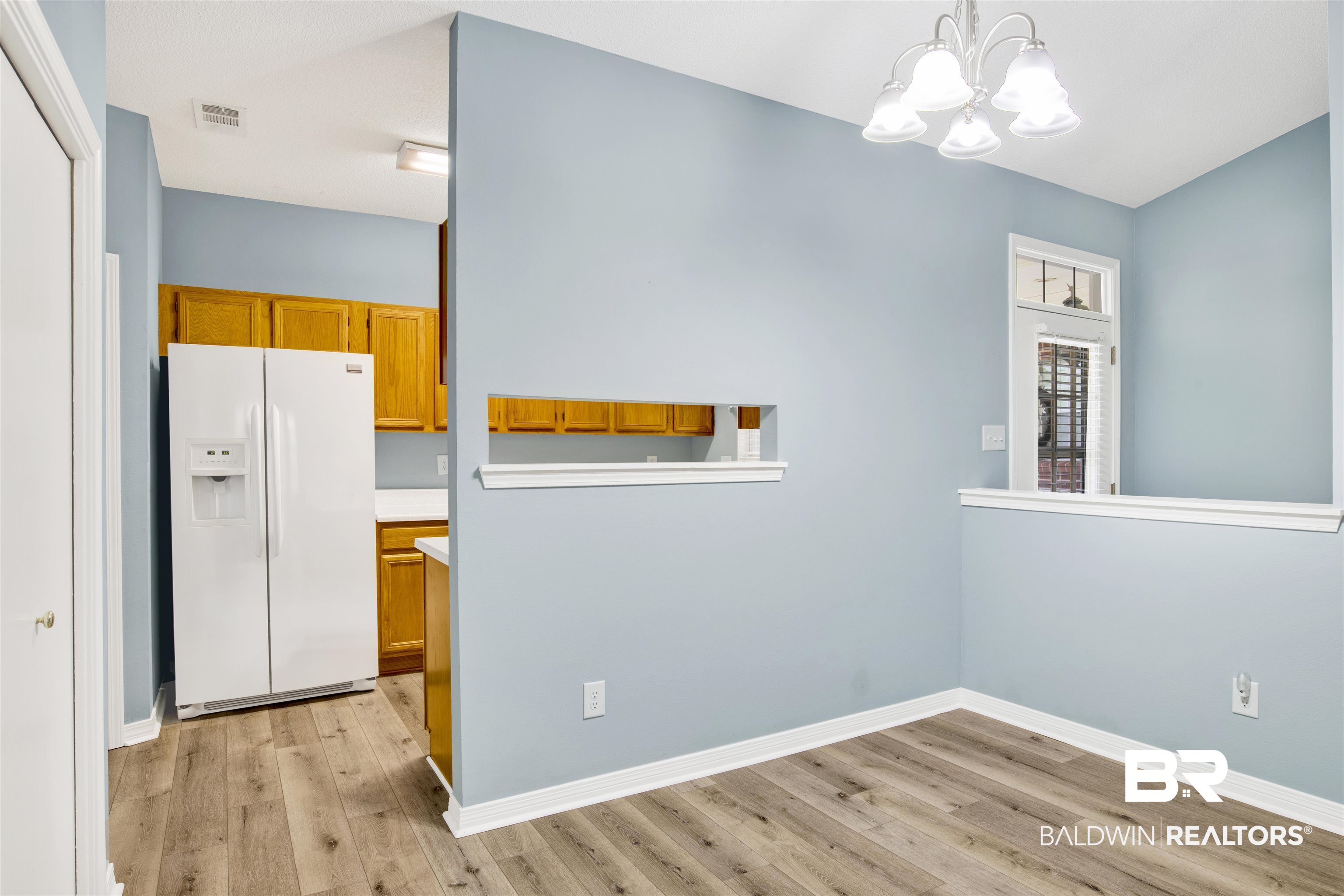 1258 Sutton Court, Unit 4 Mobile, AL 36609 - Photo 7 of 19 Unfurnished dining area featuring light wood-type flooring, baseboards, a notable chandelier, and visible vents