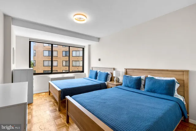 a bedroom with two beds and a large window