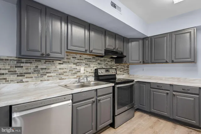 a kitchen with a stove top a washer and dryer