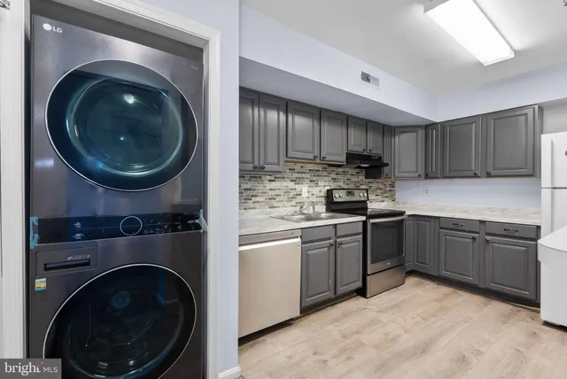 a utility room with cabinets and stainless steel appliances