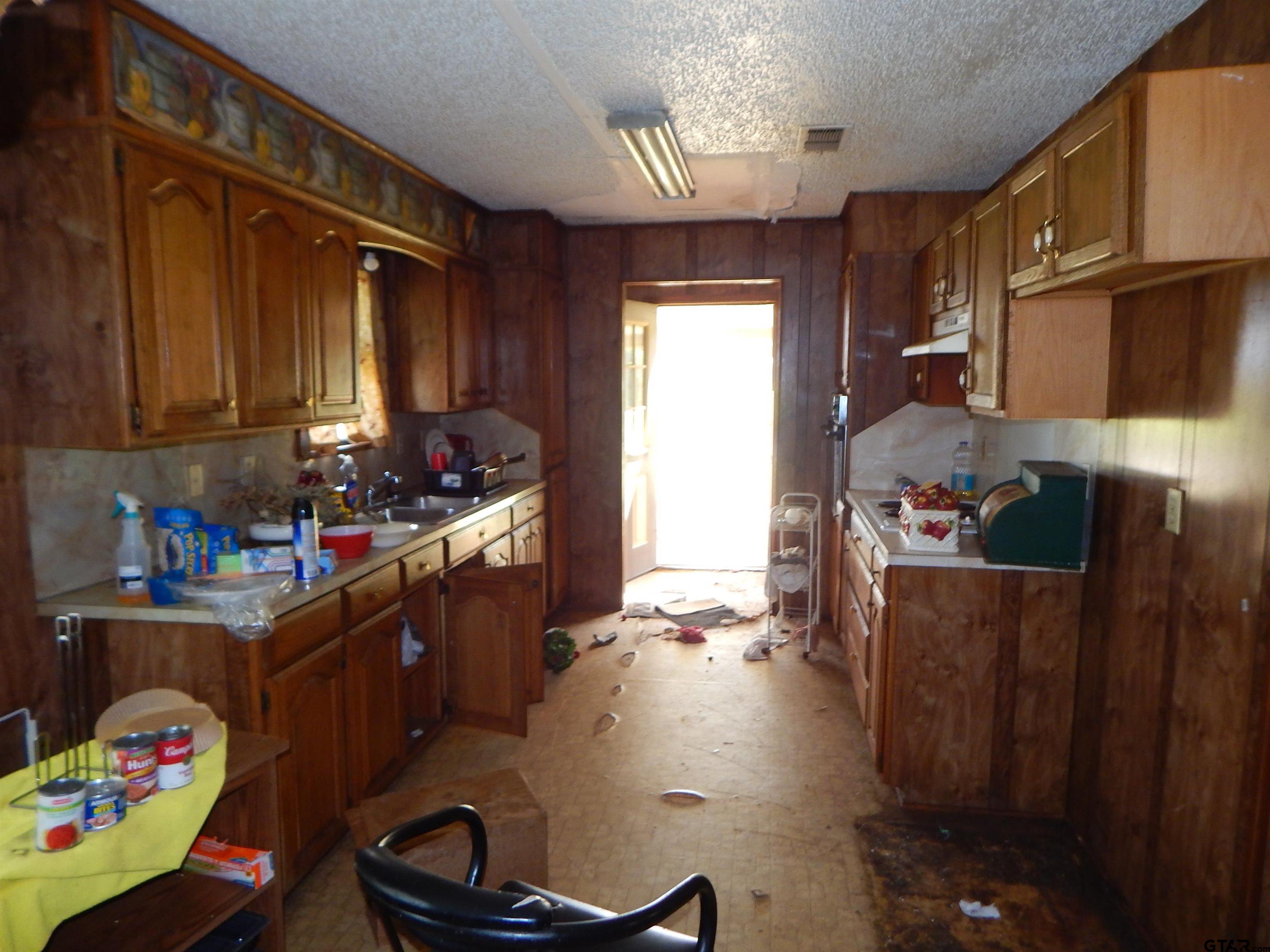2741 Toad Road Gilmer, TX 75644 - Photo 13 of 20 a kitchen with granite countertop lots of clutter and stainless steel appliances