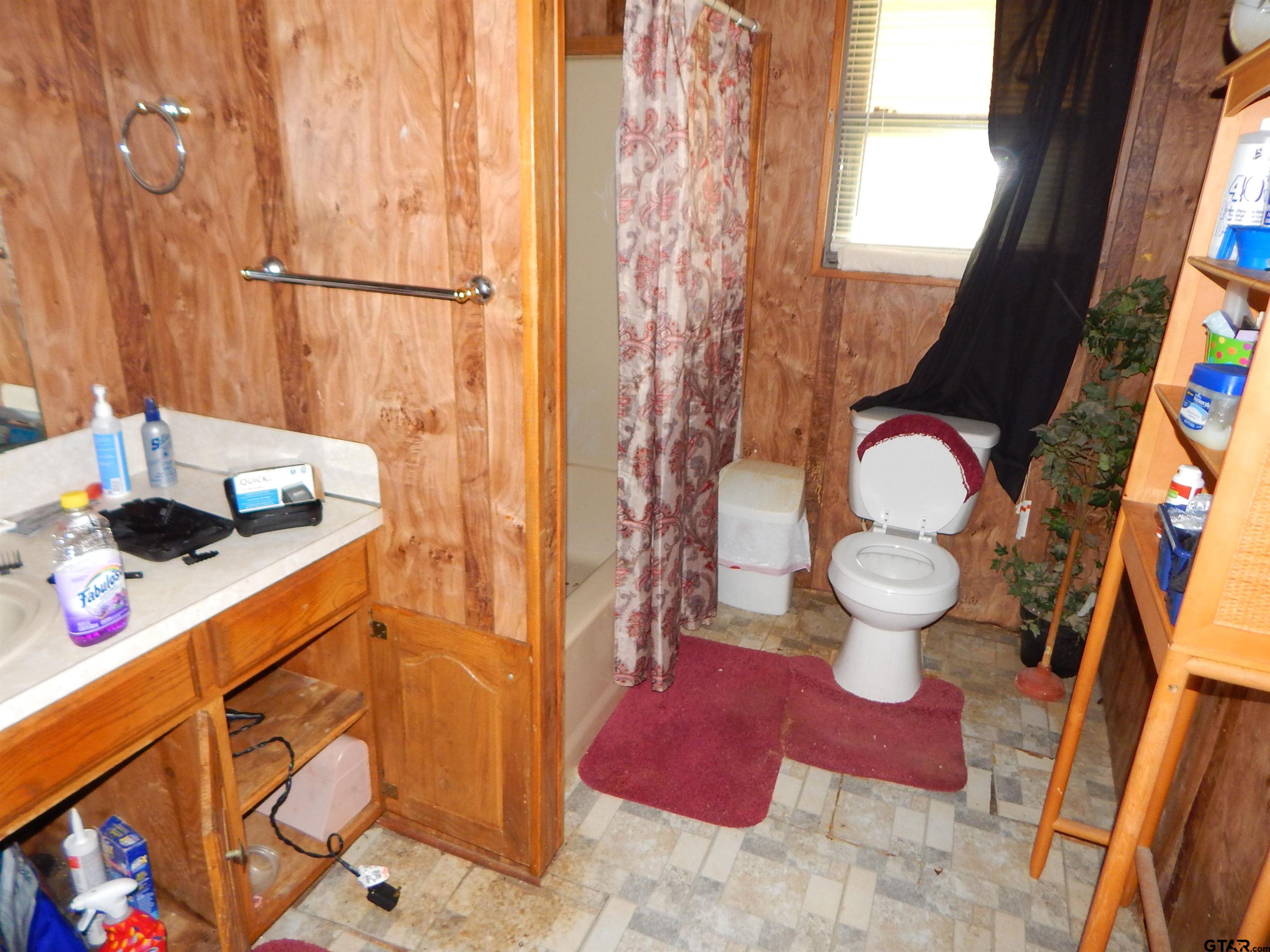 2741 Toad Road Gilmer, TX 75644 - Photo 16 of 20 a bathroom with a sink toilet and shower