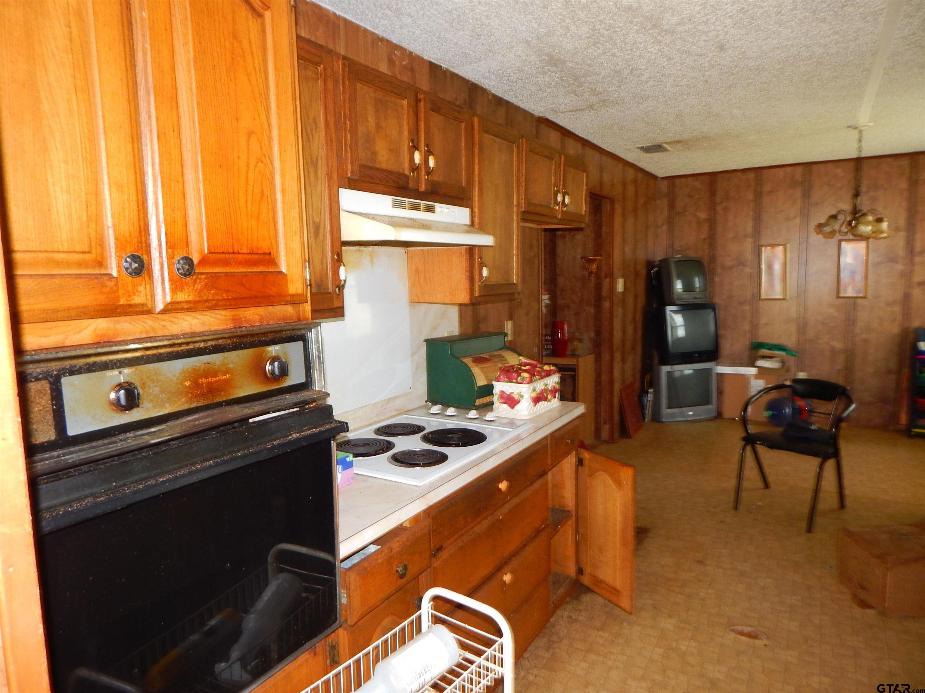 2741 Toad Road Gilmer, TX 75644 - Photo 10 of 20 a kitchen with stainless steel appliances kitchen island granite countertop a stove and a sink