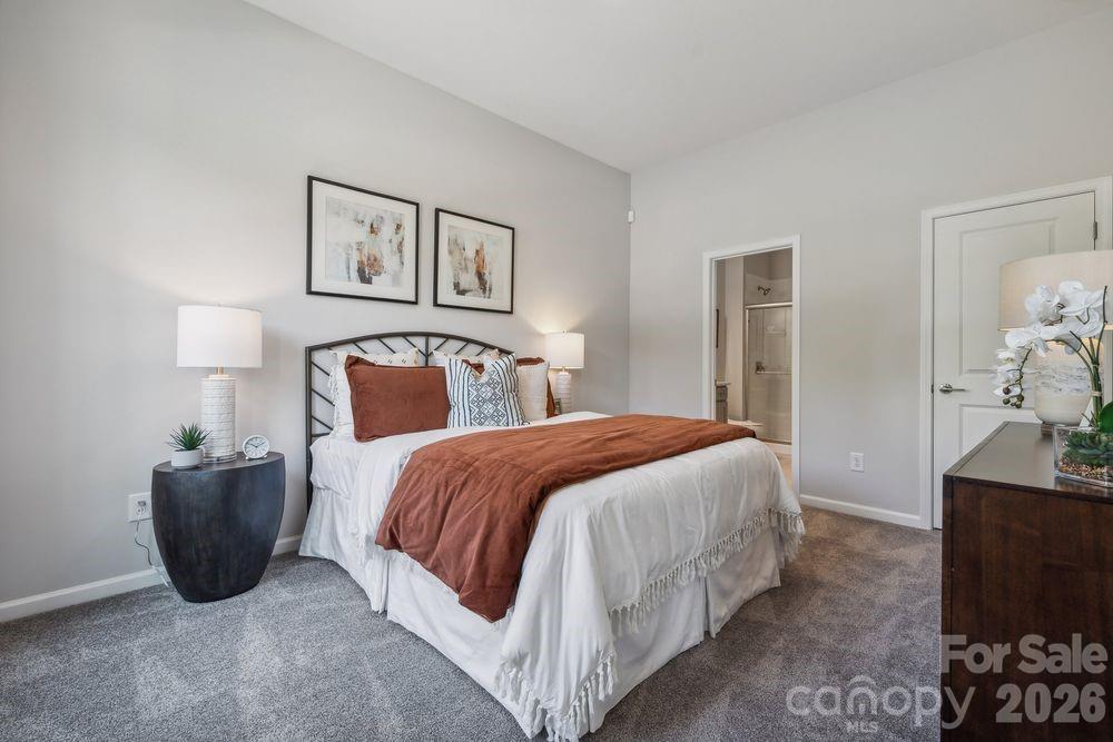 3168 Beacon Hts Road Indian Land, SC 29707 - Photo 13 of 36 a spacious bedroom with a bed and a lamp