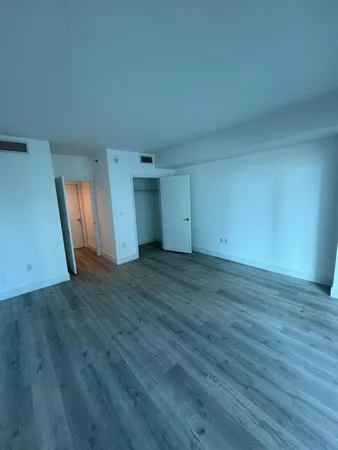 an empty room with wooden floor and window