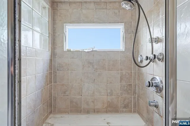 a bathroom with a glass shower door and a window