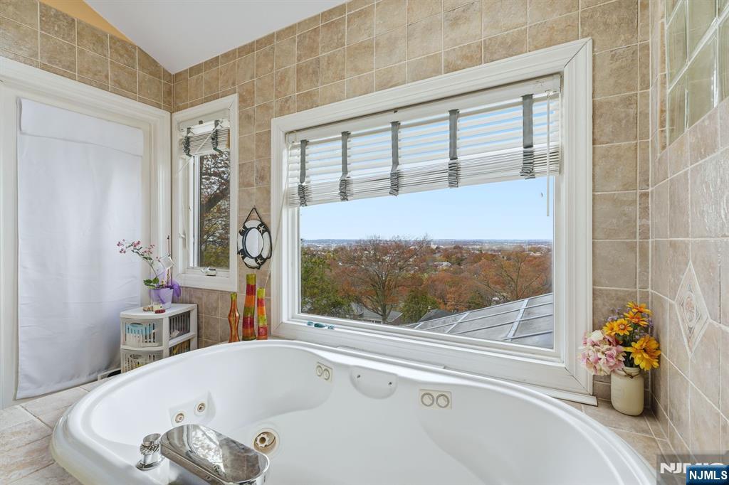 703 Stewart Street Ridgefield, NJ 07657 - Photo 21 of 38 a bathroom with a tub and a potted plant