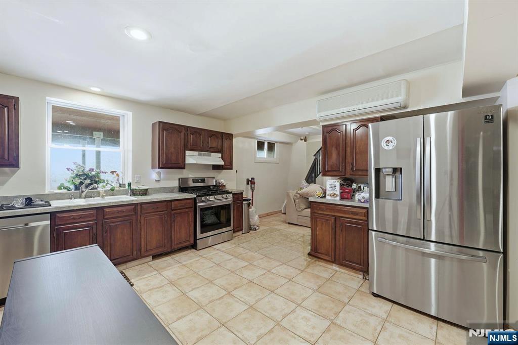 703 Stewart Street Ridgefield, NJ 07657 - Photo 24 of 38 a kitchen with stainless steel appliances granite countertop a refrigerator sink and stove